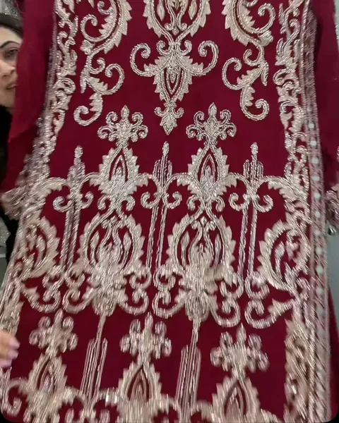 Maroon suit covered in cream and silver embroidery
