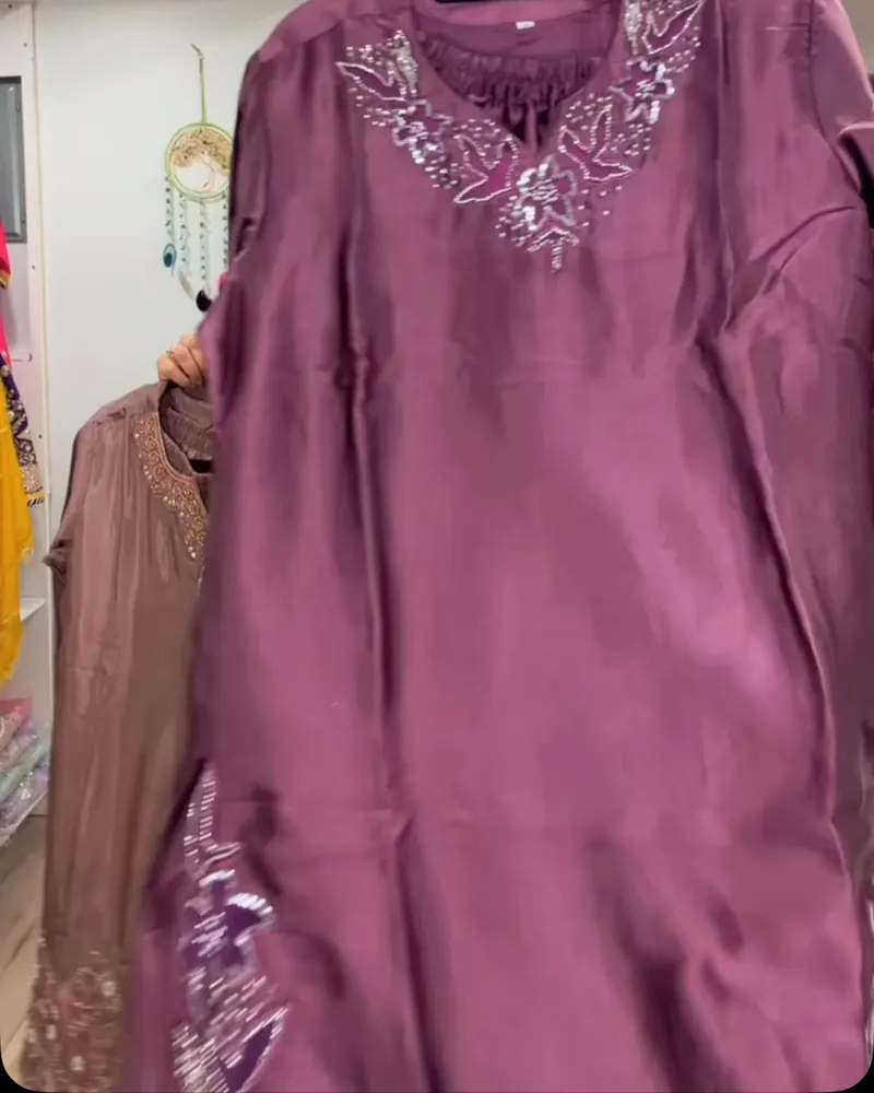 Mauve suit with an embroidered neckline held up in the boutique